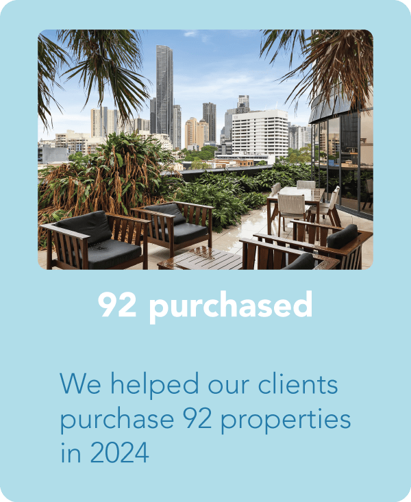 A modern outdoor seating area with wooden furniture and tropical plants, overlooking a city skyline, with text indicating that 92 properties were purchased.
